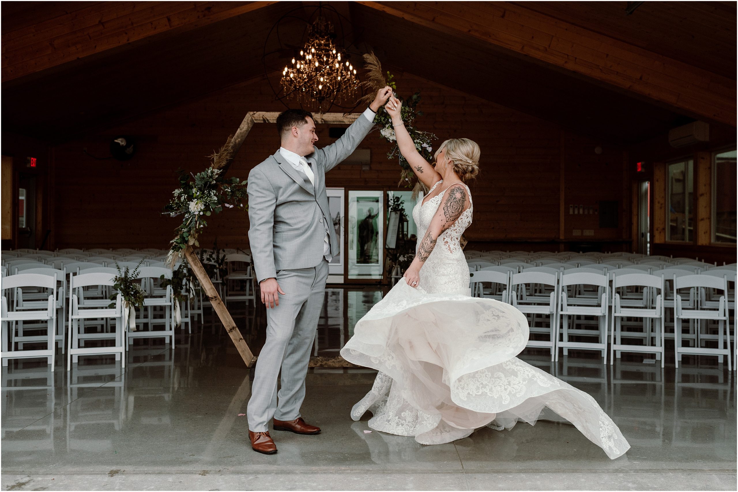 Bride and Groom dance and spin in front of Sparks Barn, an Omaha NE wedding Venue. Photo taken by Nebraska wedding photographer, Anna Brace.