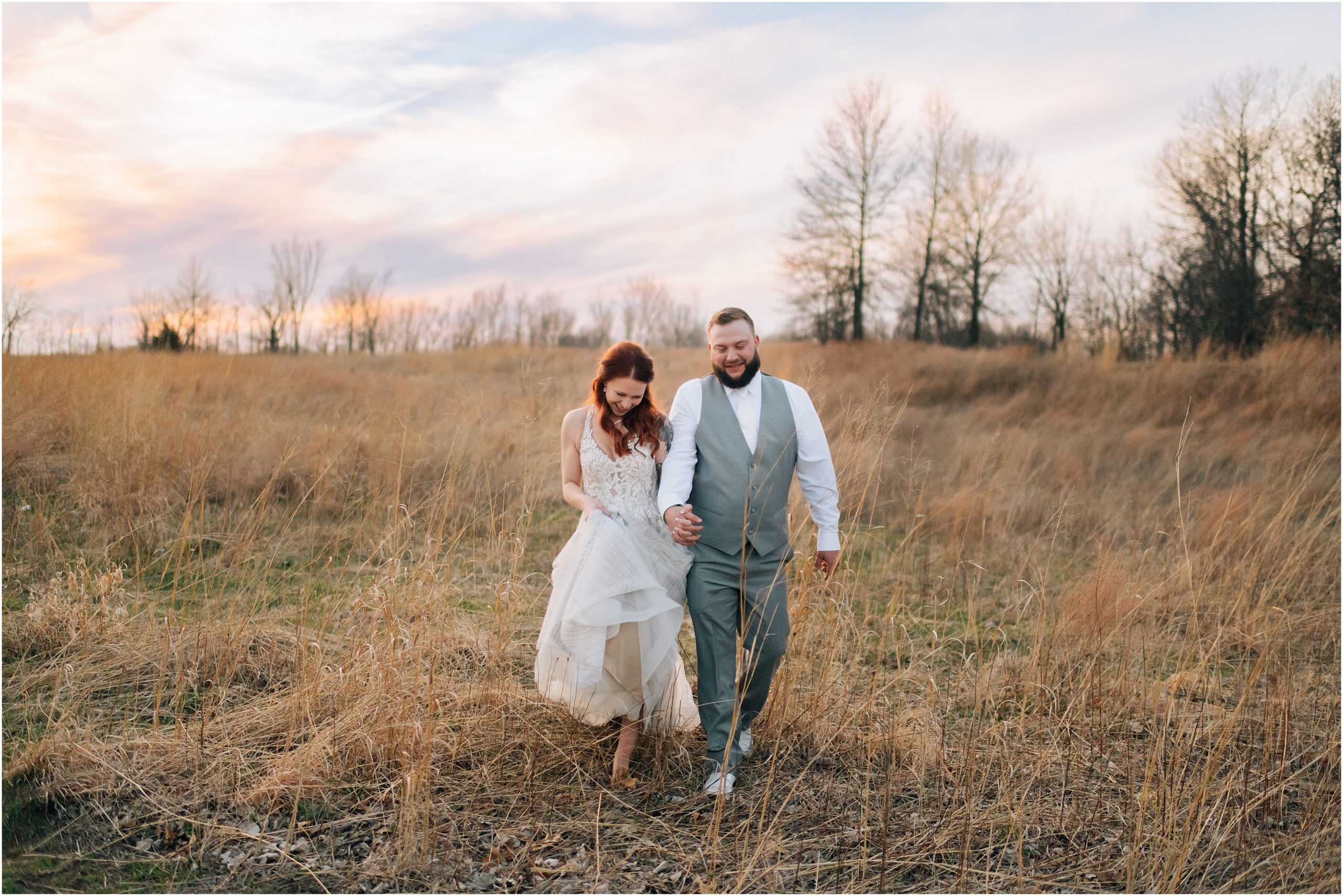 Couple walks through a field at Honey Creek Resort, Iowa - taken by Omaha wedding photographer, Anna Brace