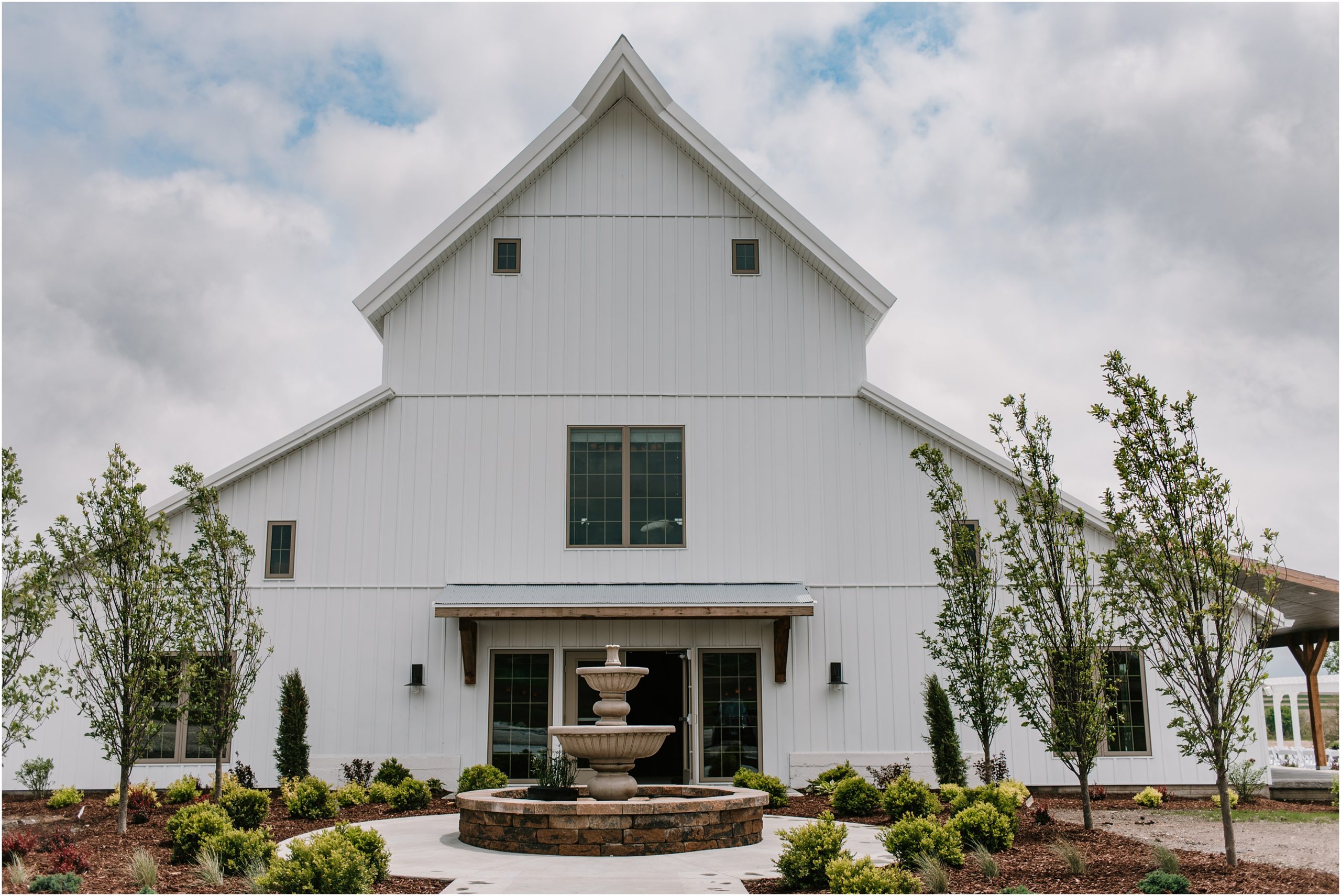 Photo of the front of The Palace Event Center, which is a large white barn by Omaha Wedding Photographer, Anna Brace