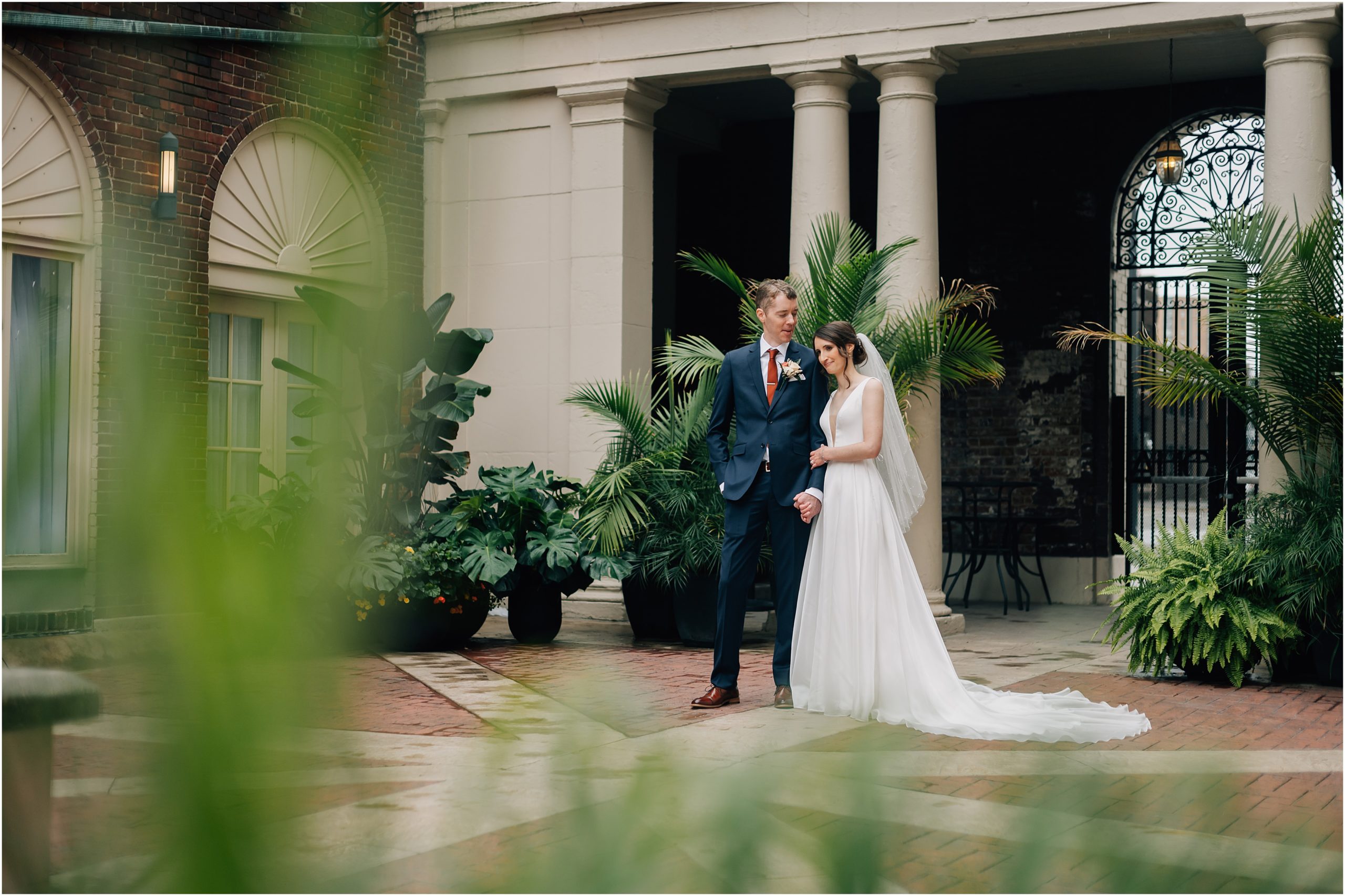 Bride and Groom hold hands in the courtyard at Magnolia Hotel, a wedding venue in Omaha, NE. Photo by Anna Brace, an Omaha Nebraska Wedding Photographer.

