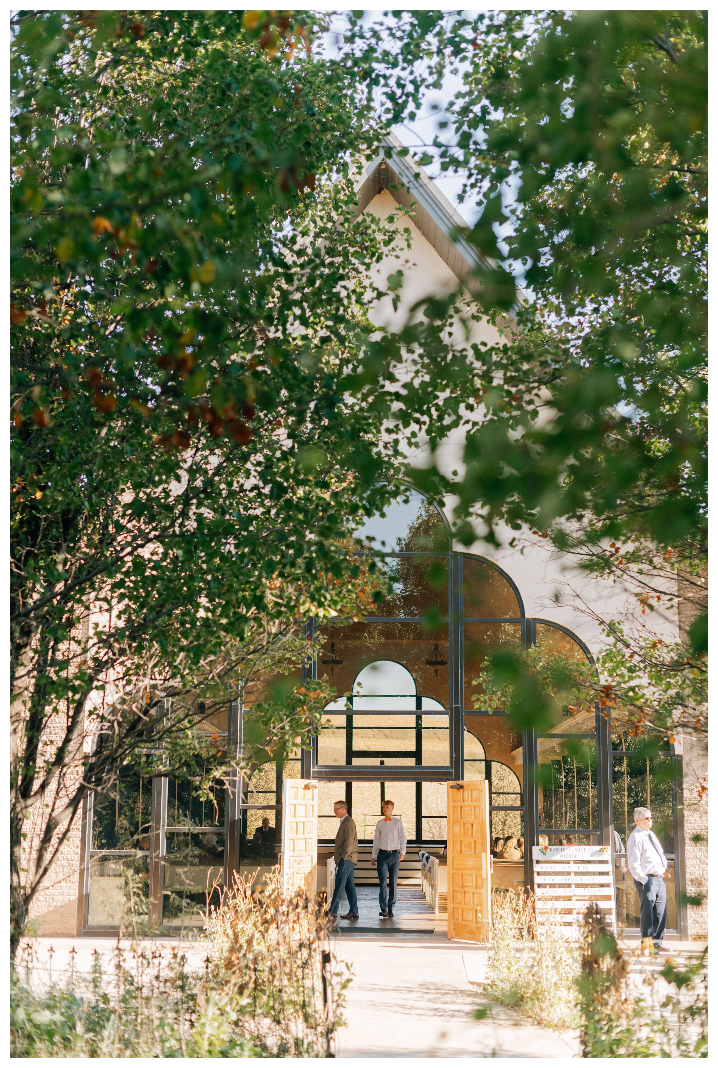 Willow Creek Glass Chapel through the trees in Shelby IA. Photo by Anna Brace, a wedding photographer in Omaha NE. 