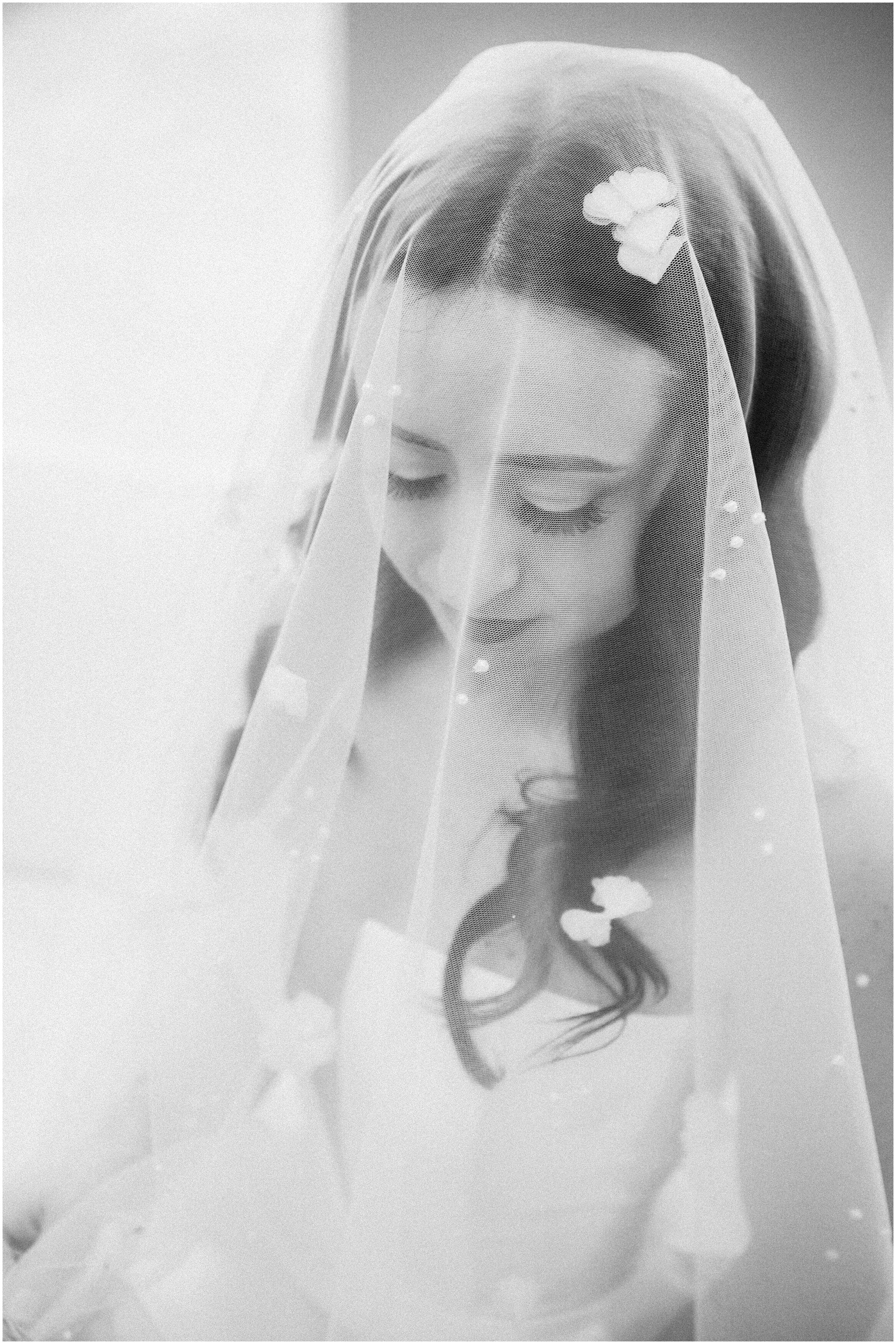 Bride looks down with a veil over her face. Taken at Magnolia Farms Adel Iowa by Anna Brace, an Omaha Nebraska Wedding photographer
