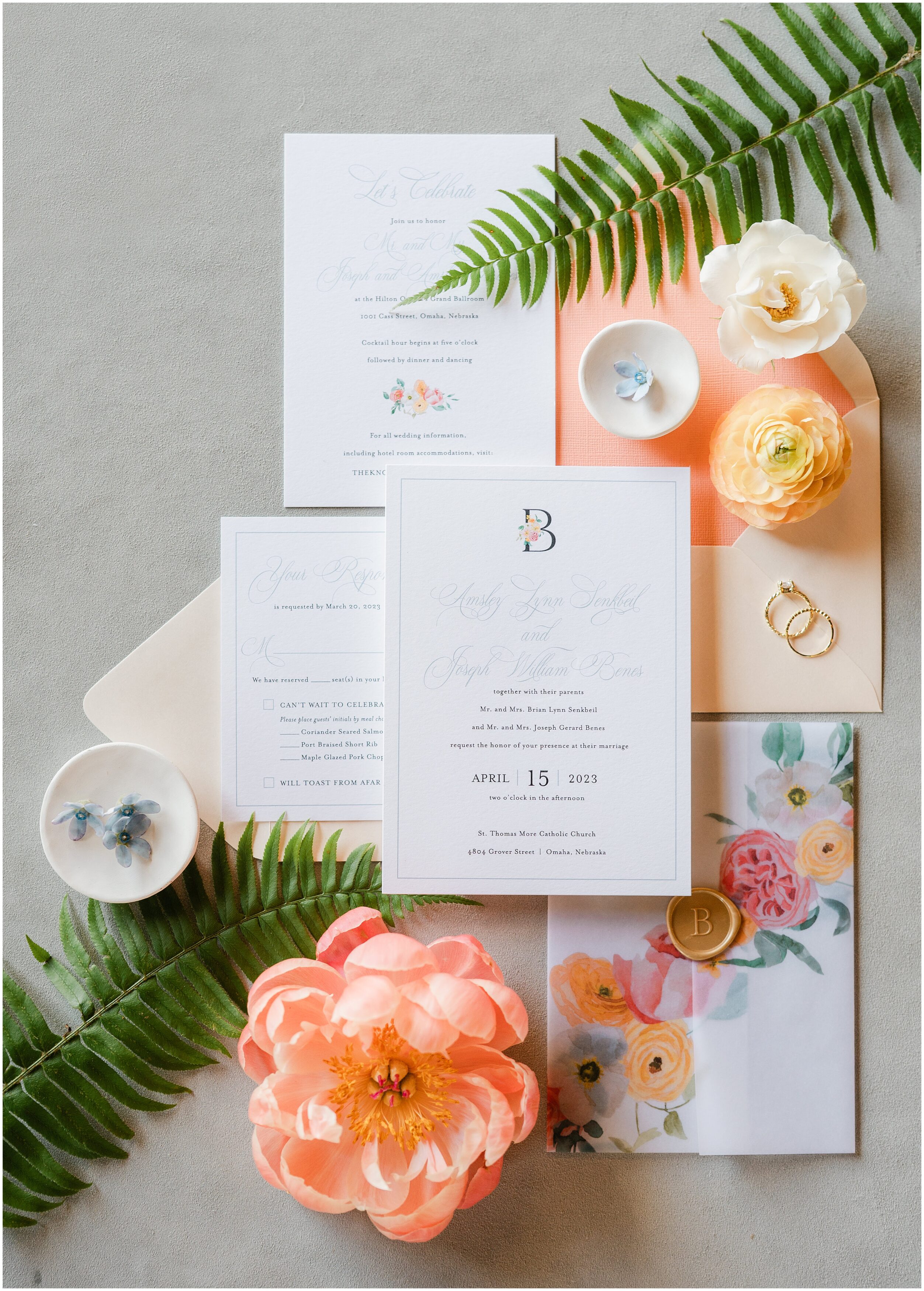 Dana Osborne Design created a white, peach, and blue wedding invitation with a vellum cover and gold details. Omaha Photography by Anna Brace.