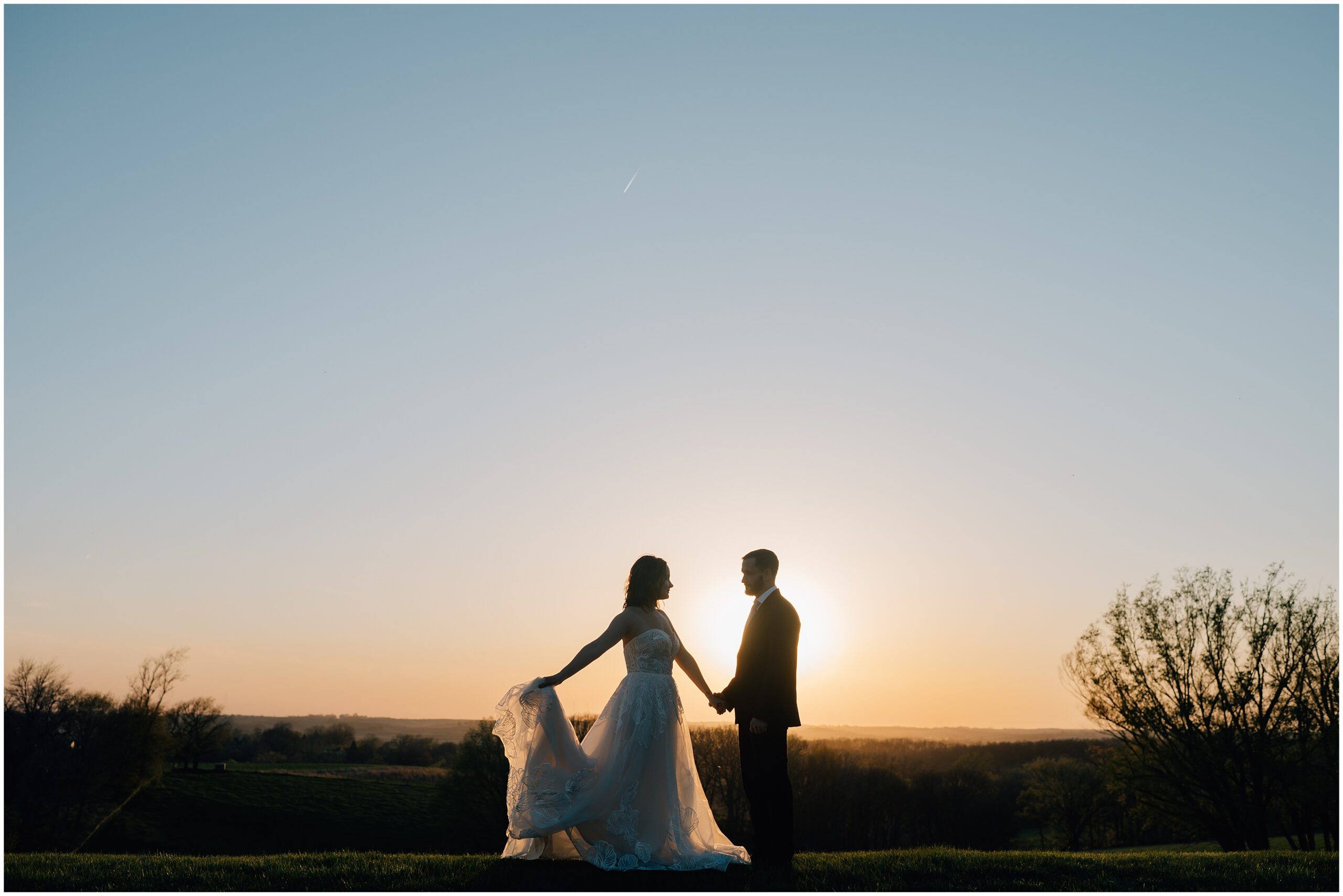 Bride and Groom dance while the sun sets behind them at The Stables at Copper Ridge, an Omaha wedding venue. Photo by Anna Brace, who specializes in Omaha NE Wedding Photography.