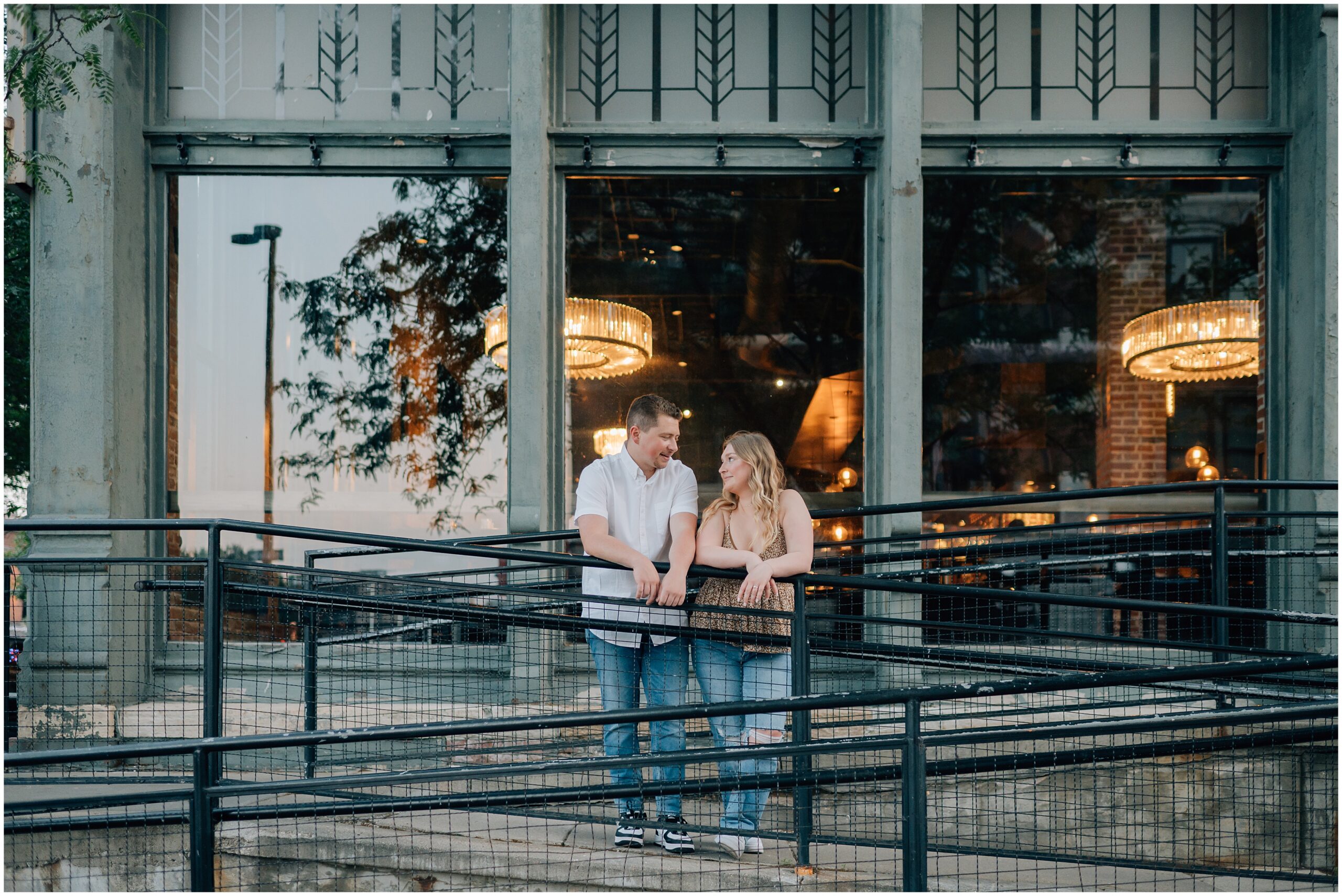 Engaged couple stands outside of a restaurant at the Old Market in Omaha. Photo by Anna Brace, who specializes in Omaha Wedding Photography.